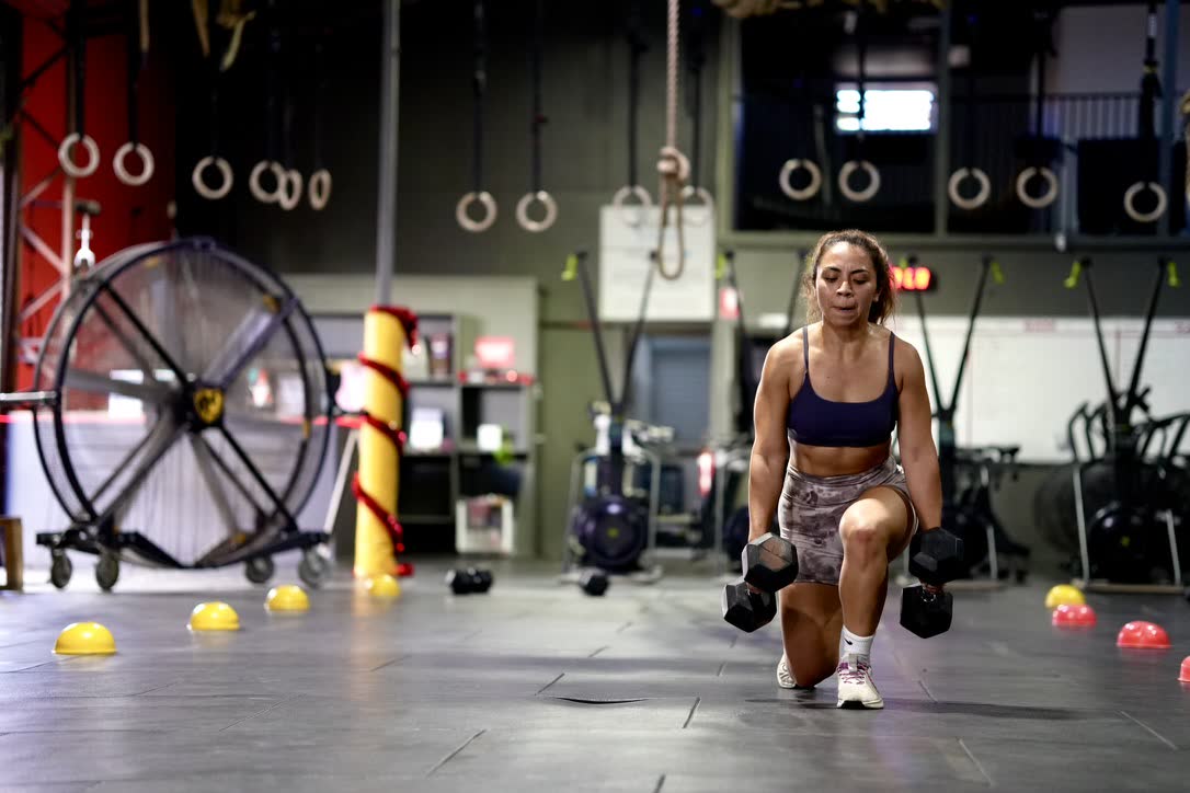 CrossFit Brisbane athlete performing dumbbell lunges in the gym