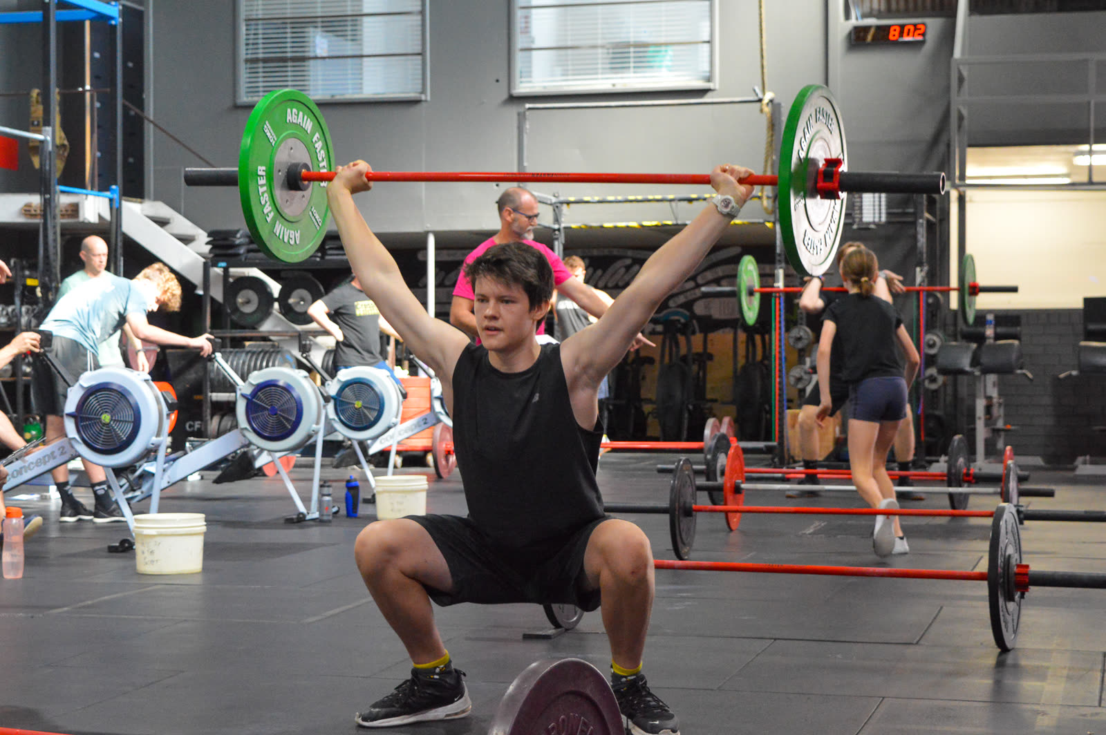 CrossFit Brisbane teen practising an overhead squat with light technique-focused loading